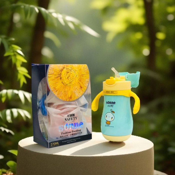Children's sippy cup with yellow lid and blue body on a pedestal with a blurred green leafy background