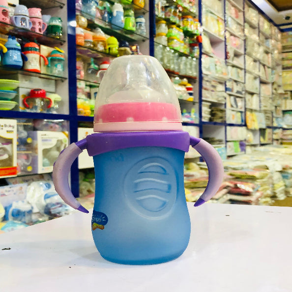 Blue and purple baby bottle with pink accents on a white surface in a store setting.